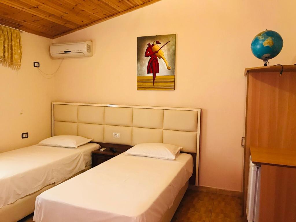 Pokój z dwoma łóżkami i obrazem na ścianie w obiekcie Gold Guest House & Bar w mieście Përmet