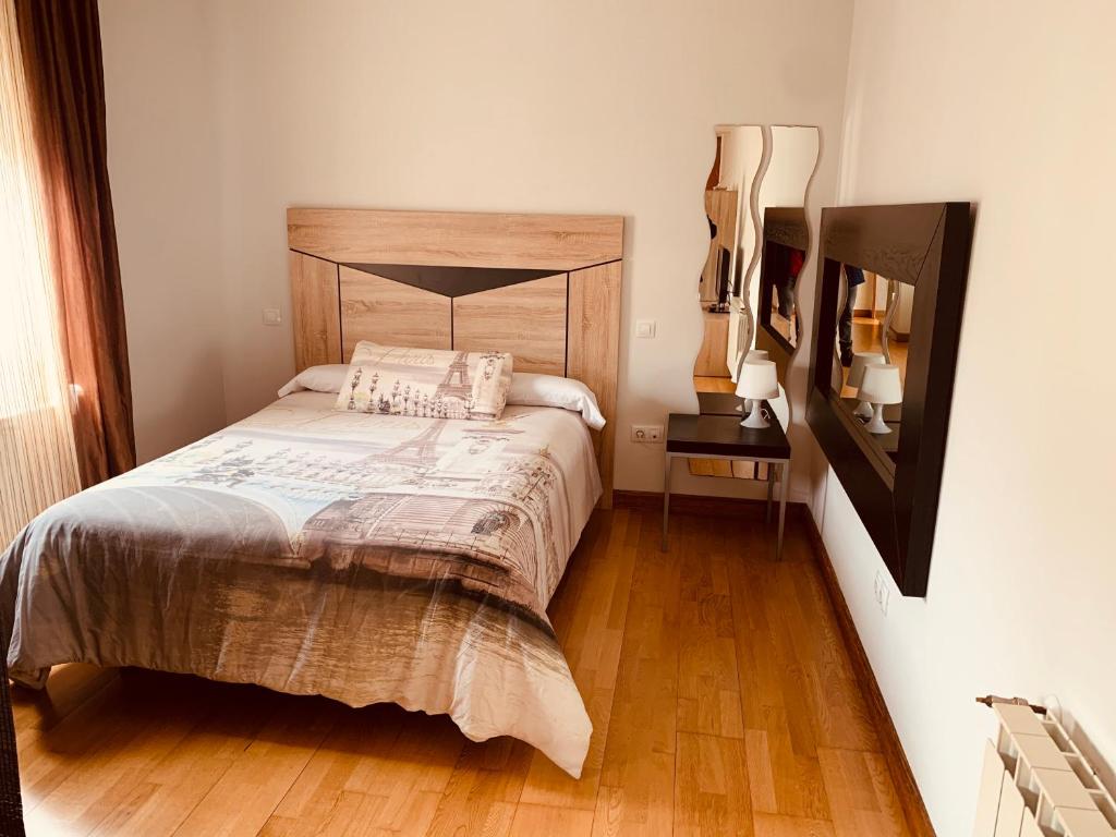 1 dormitorio con 1 cama con cabecero de madera en Estudios Blanmart, en Santander