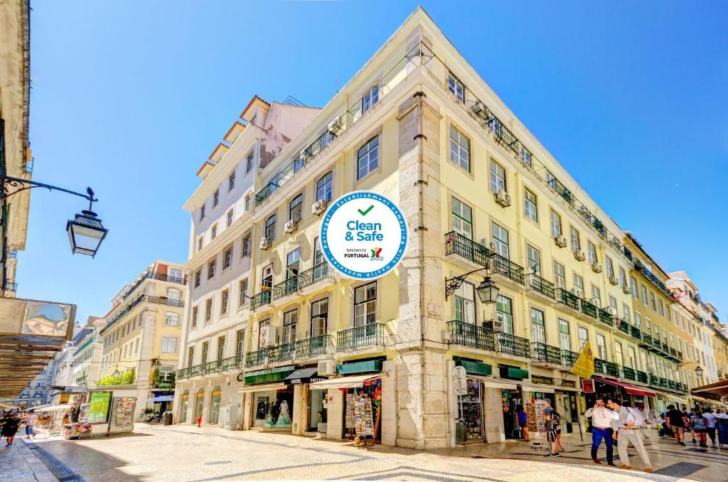 un grand bâtiment avec un panneau sur son côté dans l'établissement Hotel LX Rossio, à Lisbonne