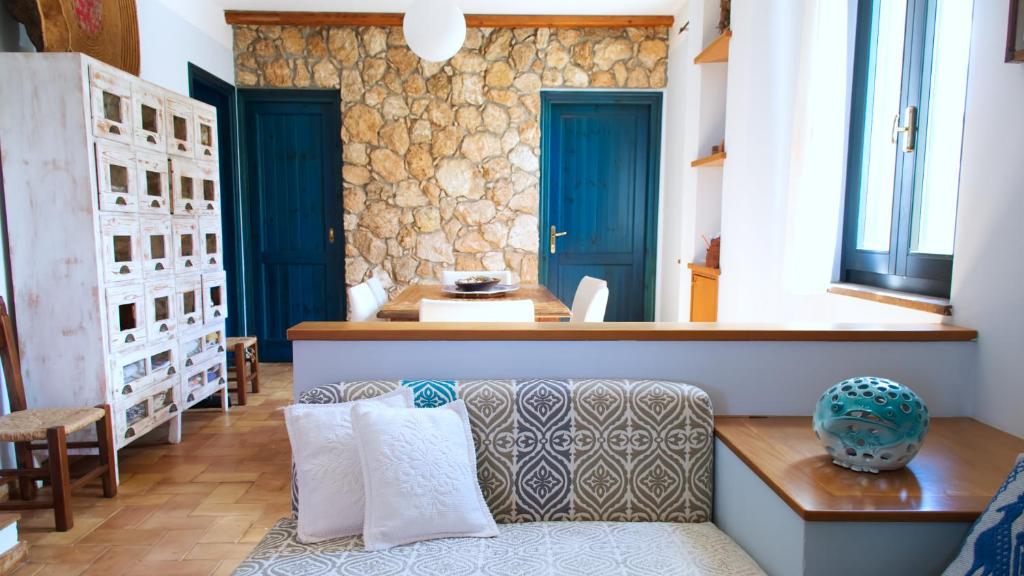 ein Wohnzimmer mit blauen Türen und einem Sofa in der Unterkunft Welcomely - Sardinian Stone House in Torre Grande