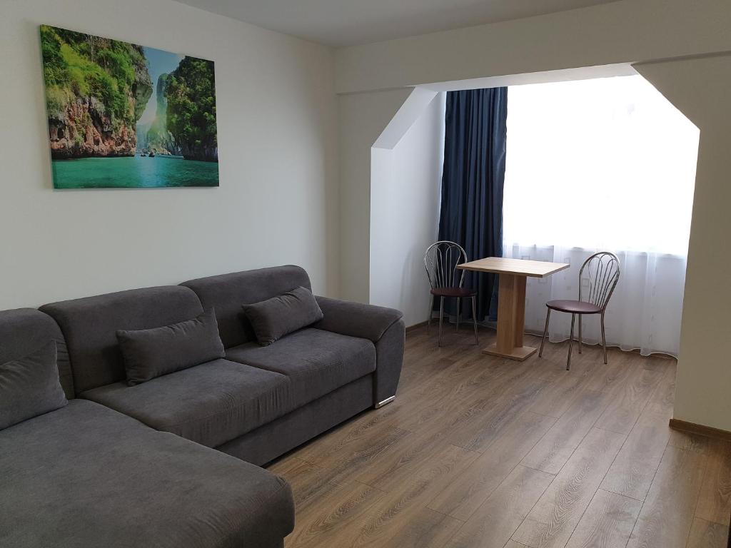 uma sala de estar com um sofá e uma mesa em Apartament Diana em Jurilovca