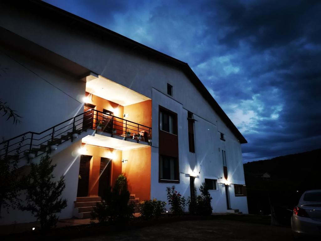 Una casa blanca con luces en el costado. en Natalia Guesthouse, en Sărata-Monteoru