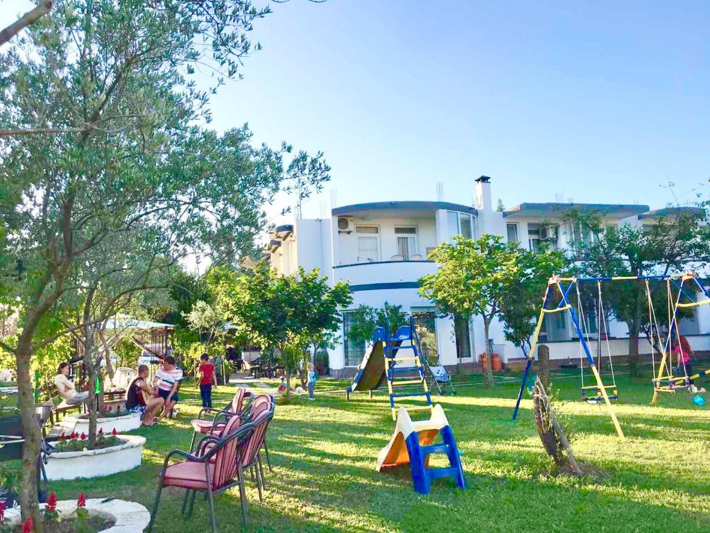 a group of people sitting in a park with a playground at Apartments Flamingo in Ulcinj