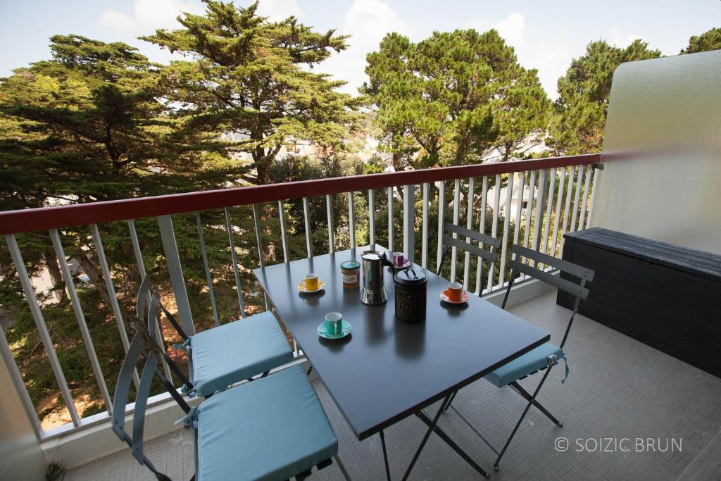 une table et deux chaises sur un balcon dans l'établissement Princess of Bel Air avec garage privé et tennis - 300m plage et commerces, à Pornichet