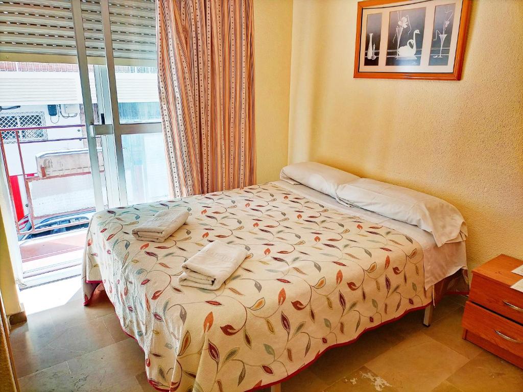 ein kleines Bett in einem Zimmer mit Fenster in der Unterkunft AB Pension Granada in Granada