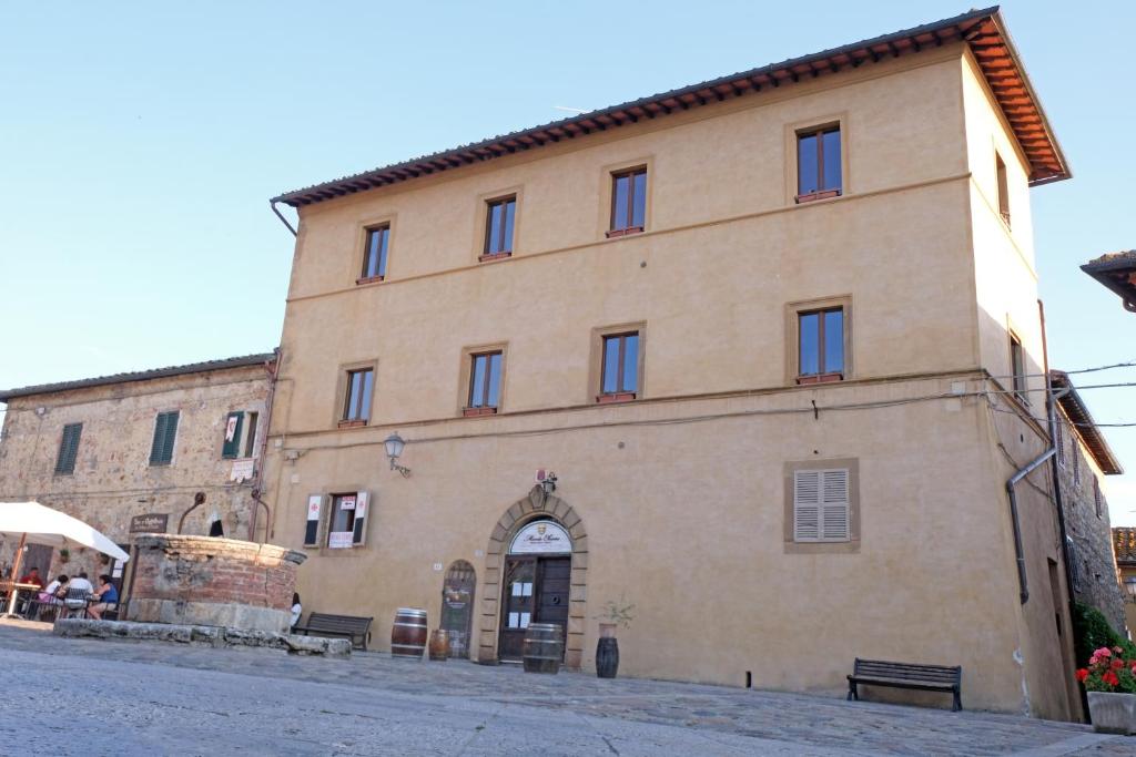un grand bâtiment en briques avec une porte dans une rue dans l'établissement Rooms and Wine al Castello, à Monteriggioni