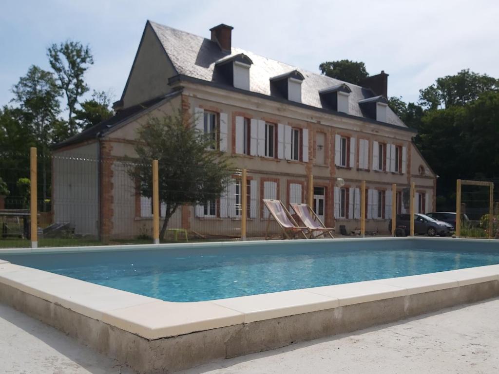 a house with a swimming pool in front of a house at Château de la Malmaison in Champillon