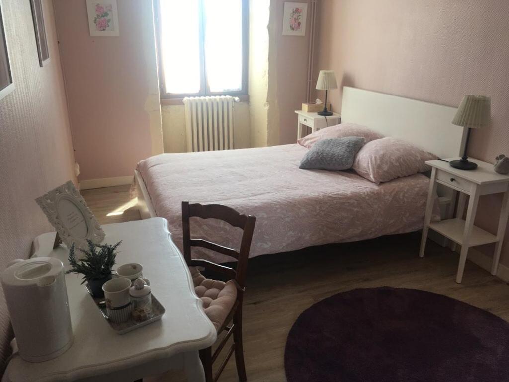 Arandas的住宿－Auberge à la Vieille Cure，卧室配有1张床、1张桌子和1把椅子