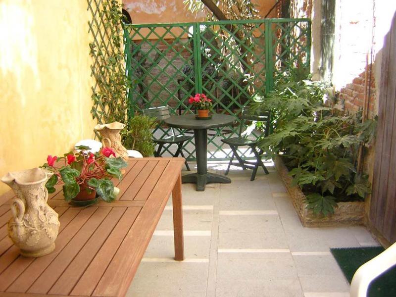 eine Terrasse mit einem Holztisch und einigen Pflanzen in der Unterkunft Casa a San Marco in Venedig