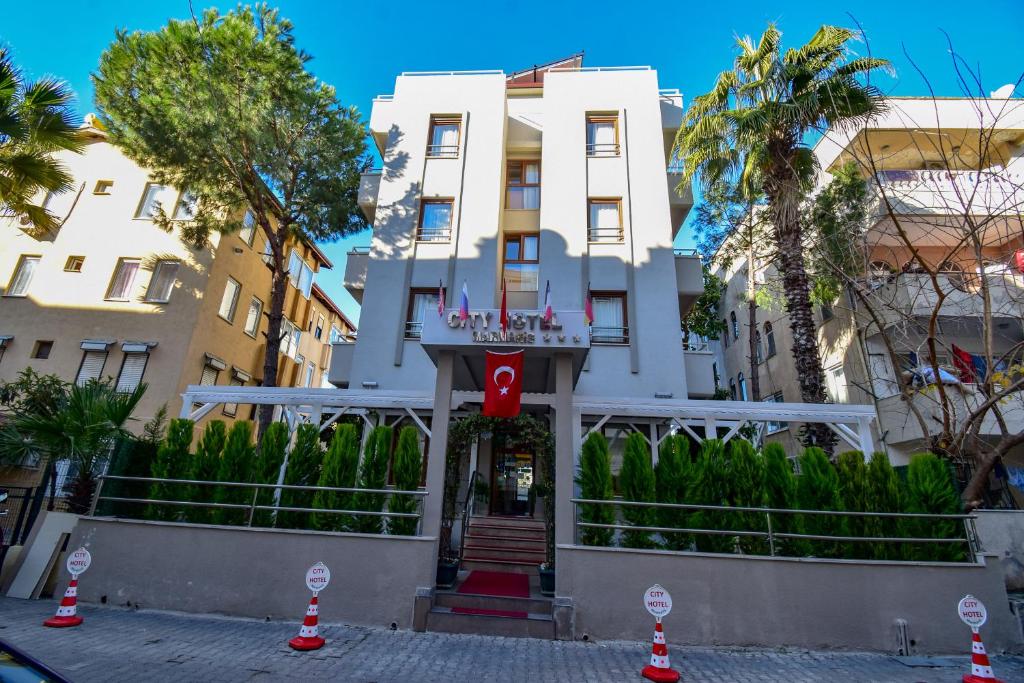 a white building with palm trees in front of it at City Hotel Marmaris in Marmaris