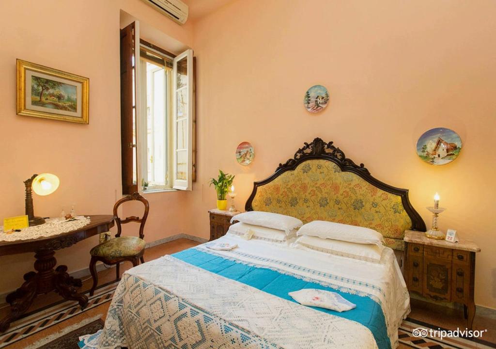 a bedroom with a bed and a table and a window at B&B Atmosfere Del Centro Storico in Naples