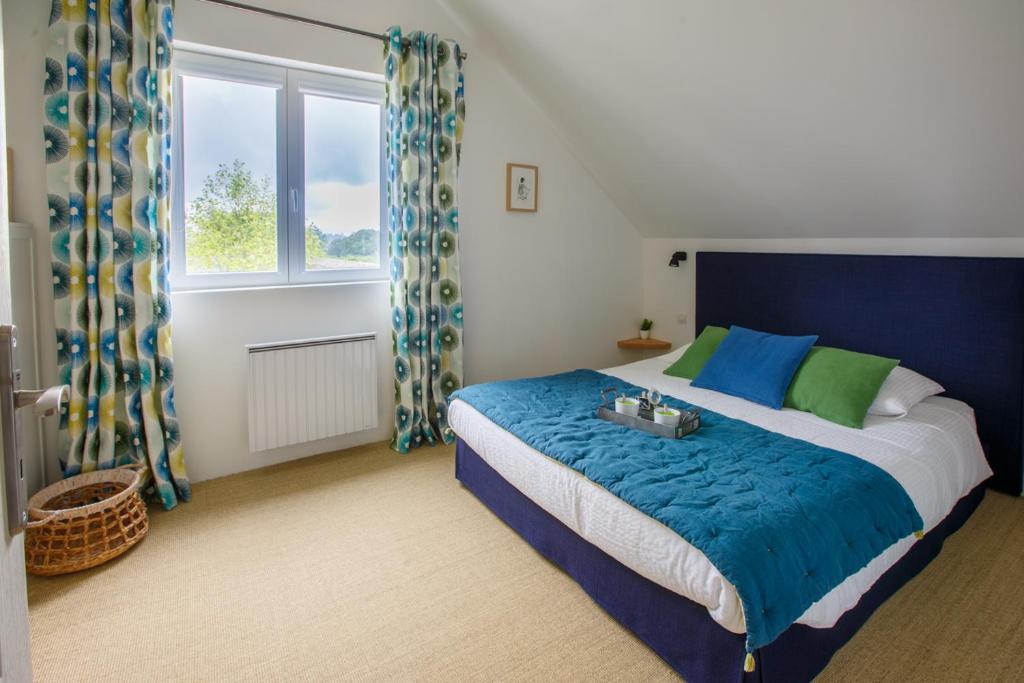 sypialnia z łóżkiem w kolorze niebieskim i zielonym w obiekcie Gîtes de charme pour 2 au calme aux portes de Bayeux by Le Clos Poulain w mieście Nonant