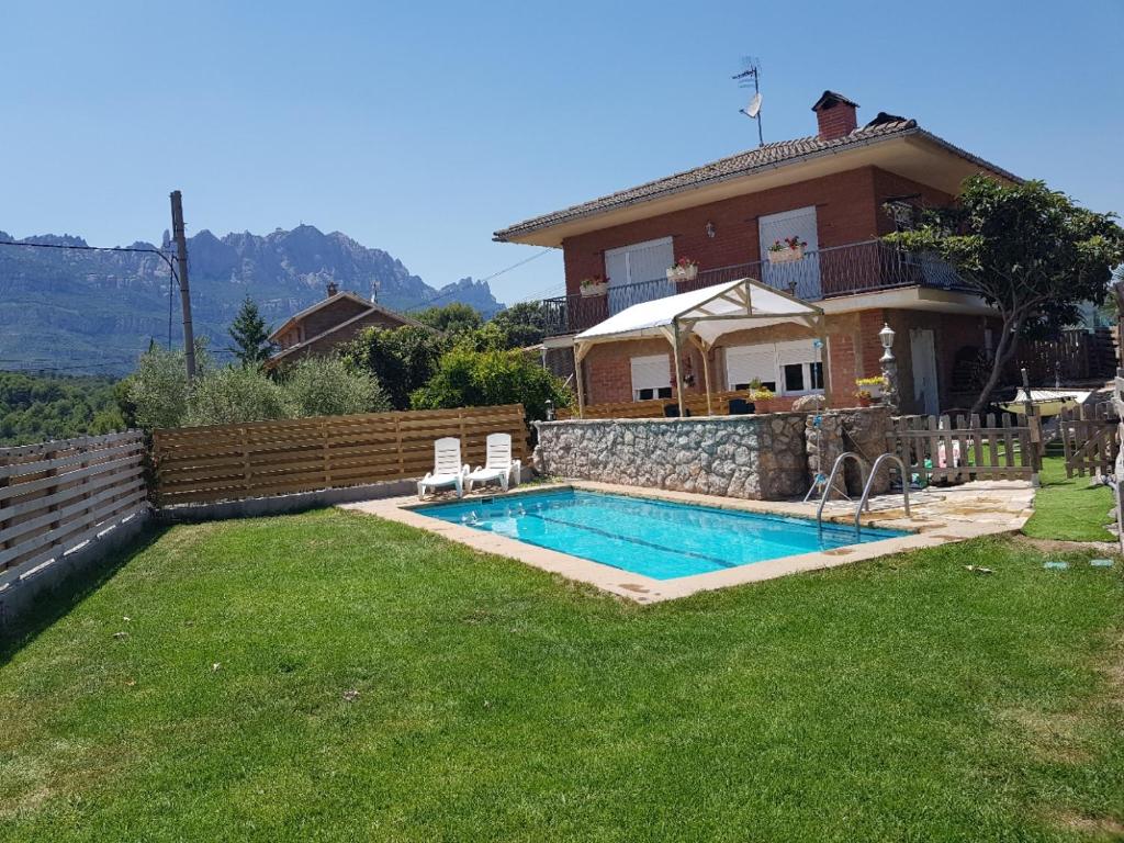 une maison avec une piscine dans une cour dans l'établissement Apartament Vall de Montserrat, à Castellbell i Vilar