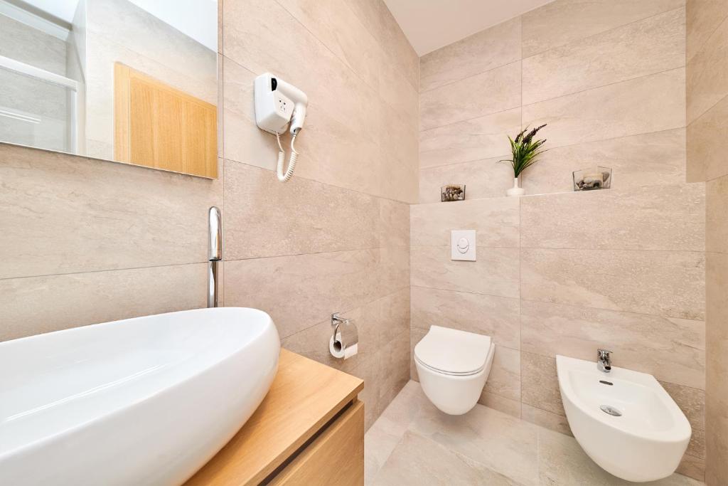 a bathroom with a white sink and a toilet at Ribarska Koliba - Villa Marija in Pula