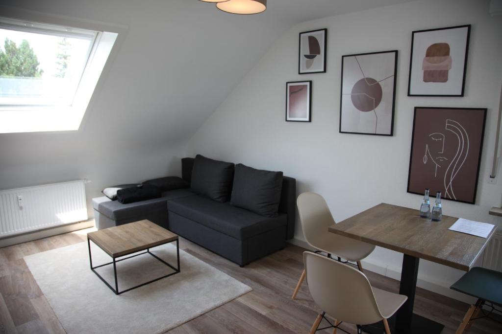 uma sala de estar com um sofá e uma mesa em Moderne 2 Zimmer Wohnung in Leinfelden in hervorragender Lage und Infrastruktur em Leinfelden-Echterdingen