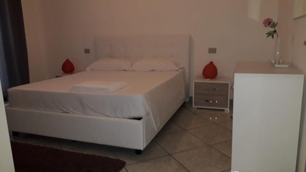 a bedroom with a white bed and a table at appartamento La Palma in Posada