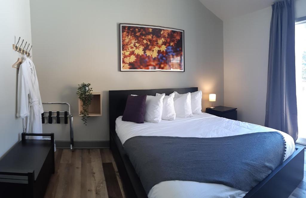 a hotel room with a large bed with white pillows at Oberge Inn Val-David in Val-David