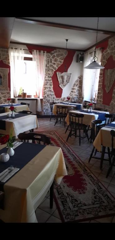 a restaurant with tables and chairs and a stone wall at Restaurant Pension in Germersheim