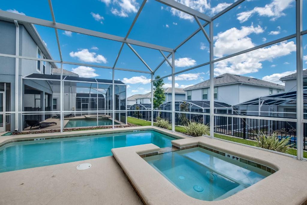 a swimming pool in the middle of a building with a glass wall at Stylish Home wPrivate Pool&Spa, near Disney in Davenport