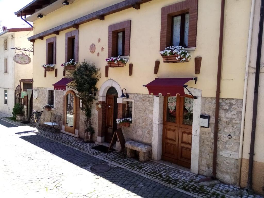 - un bâtiment avec des portes en bois dans une rue dans l'établissement Albergo Andromeda, à Pescasseroli