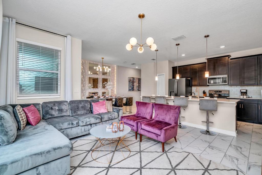 a living room with a couch and a kitchen at Private Pool Themed Bedrooms FREE Waterpark in Kissimmee