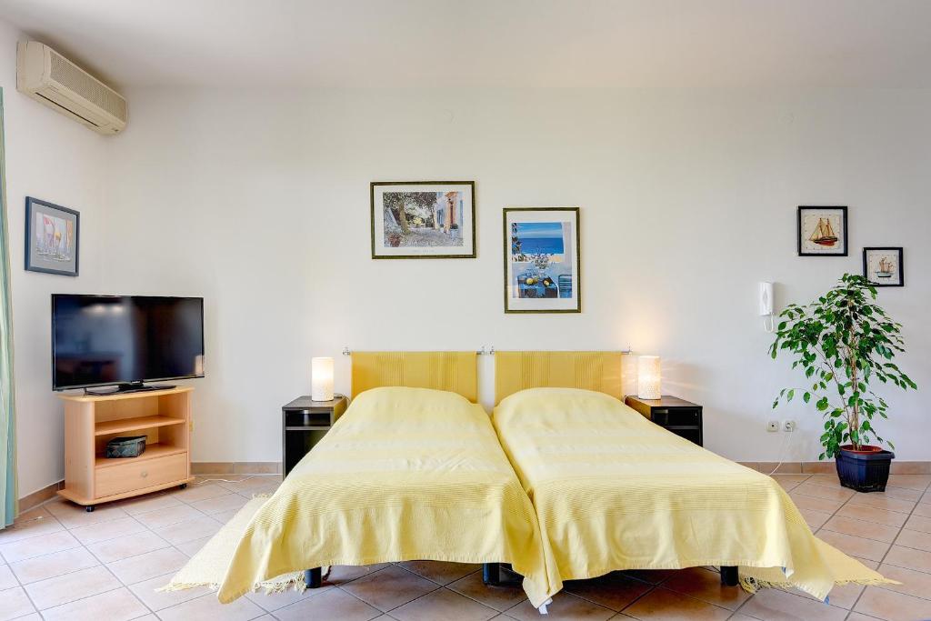 a bedroom with a bed and a flat screen tv at Apartments Villa Ana in Medulin
