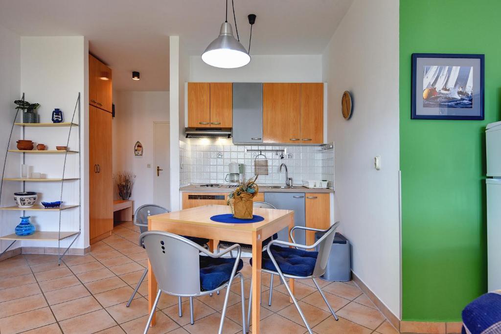 a kitchen with a wooden table and chairs at Apartments Villa Ana in Medulin