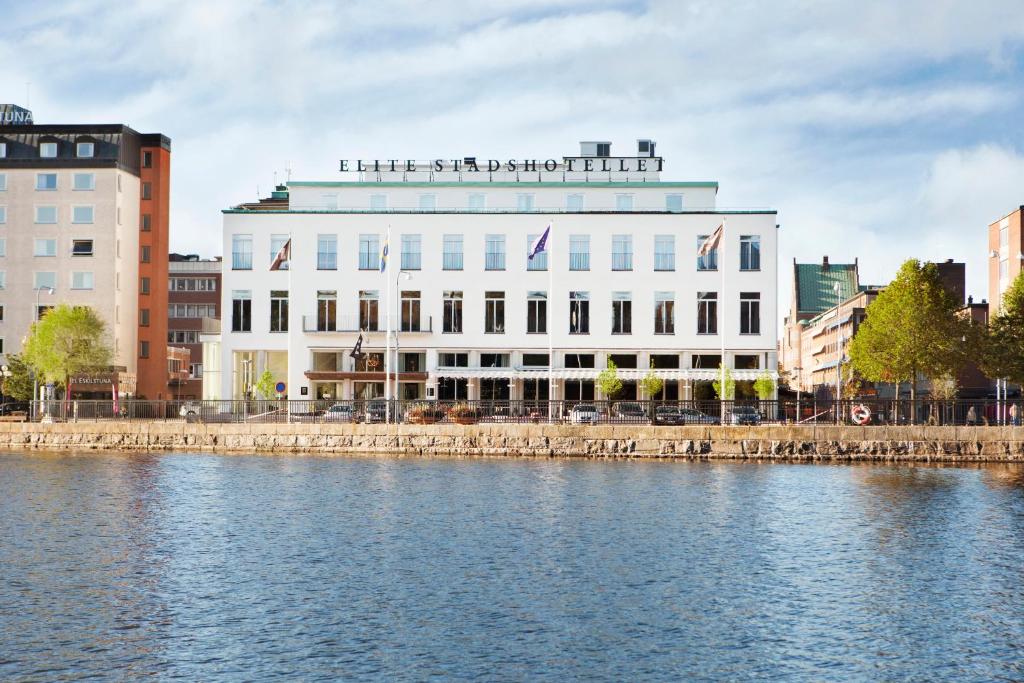 een groot wit gebouw naast een waterlichaam bij Elite Stadshotellet Eskilstuna in Eskilstuna