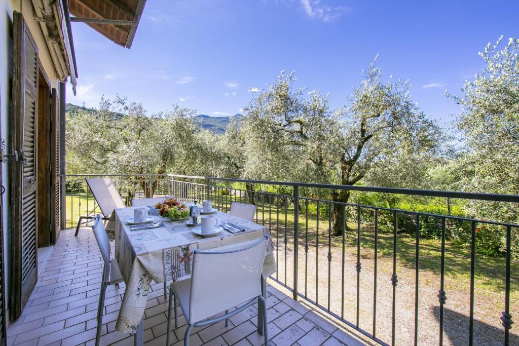 a patio with a table and chairs on a balcony at Villa Maria Paola in Nago-Torbole