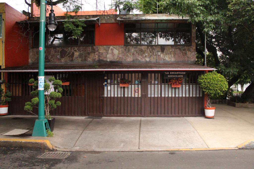 um edifício com uma frente de loja com uma cerca em Hostal La Encantada em Cidade do México