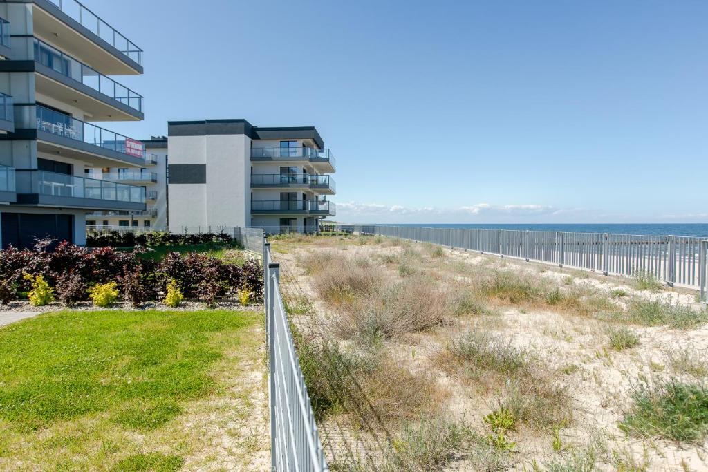 a walkway to the beach near a building at Apartament MILAN Gardenia Dziwnów z widokiem na morze EPapartamenty in Dziwnów