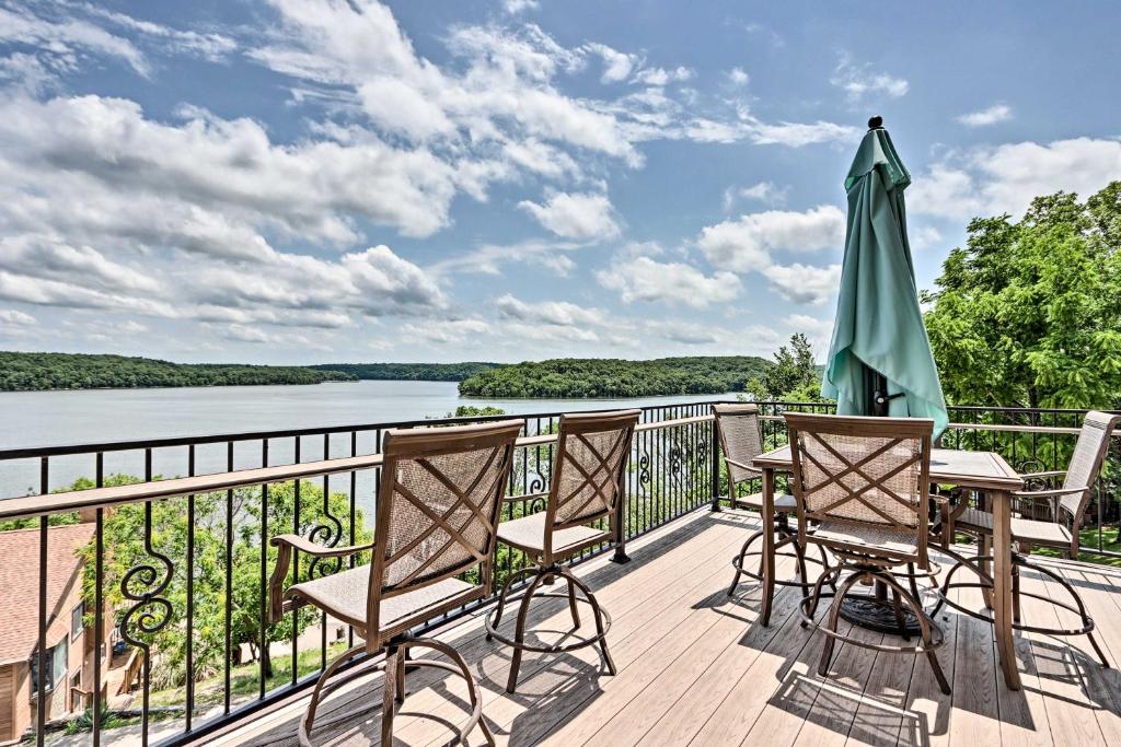 una terraza con mesa, sillas y sombrilla en Luxury Lake of the Ozarks Home with Boat Dock!, en Kaiser