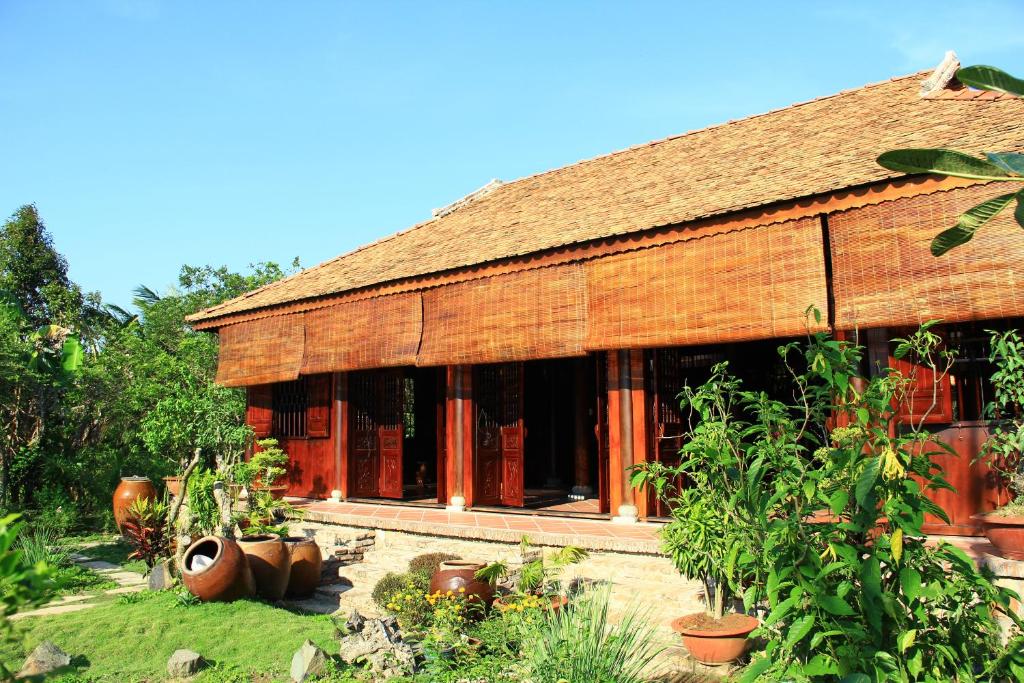 Ein Haus mit einem Haufen Pflanzen davor. in der Unterkunft Gite Nam Hien Mekong in Cho Lach