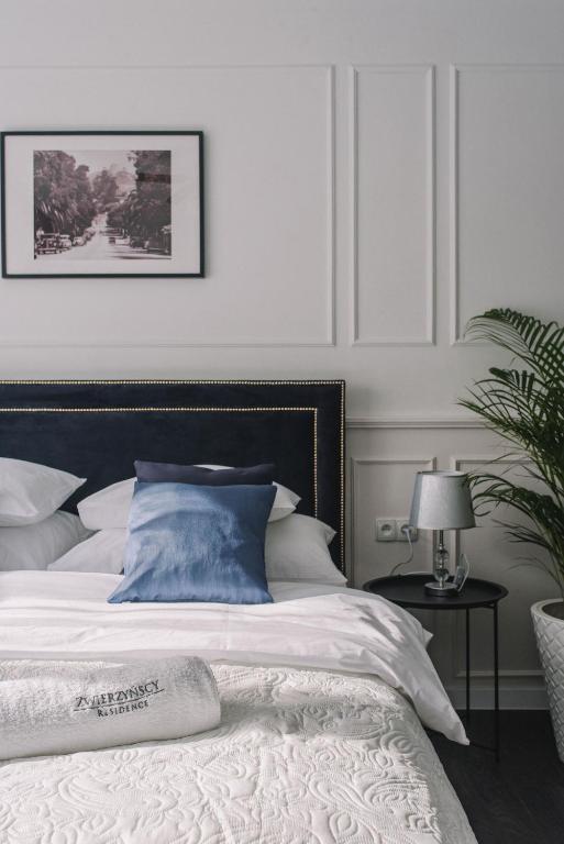 a bedroom with a white bed with a black headboard at Zwierzyńscy Residence 2 in Pobierowo