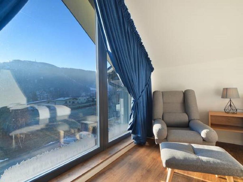 uma sala de estar com um sofá e uma grande janela em Apartament Marron 12 z sauną, bawialnią i widokiem na Skrzyczne - Dream Apart em Szczyrk