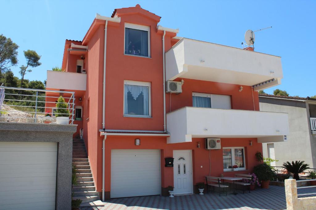 uma casa vermelha com duas garagens em Apartments Grmaca em Trogir