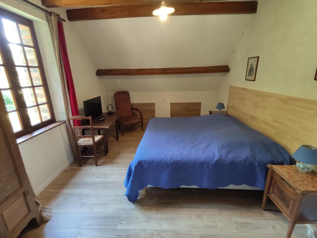 a bedroom with a blue bed and a desk at Chambres d'hôtes Domaine De La Jonquière, Bouloire in Bouloire