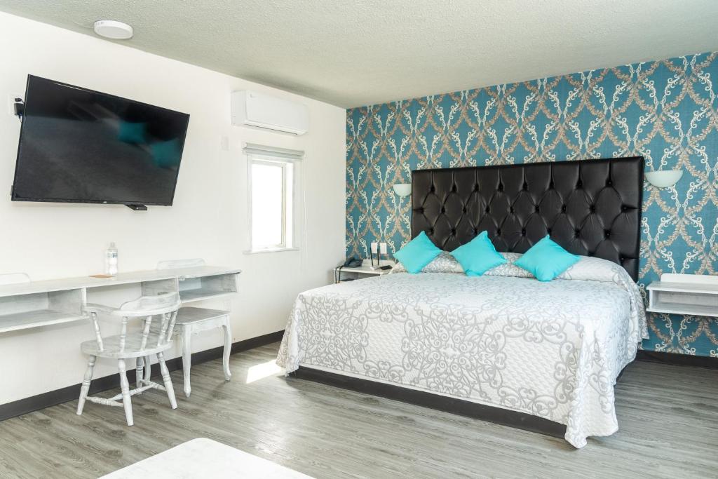 1 dormitorio con 1 cama con pared azul en Grand Hotel KYRIOS Veracruz en Veracruz