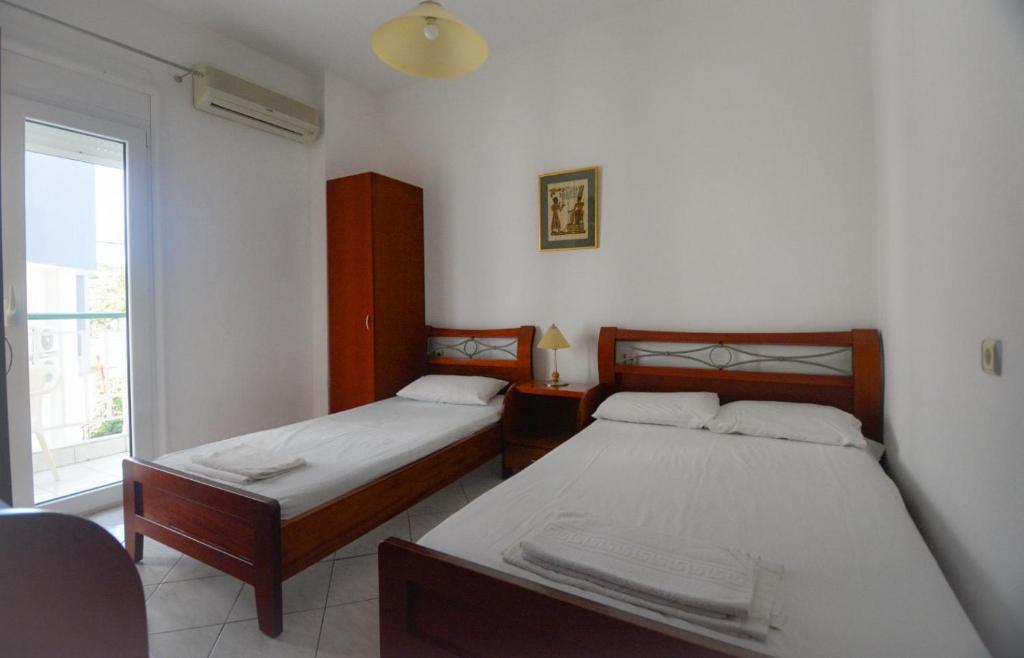 two beds in a room with a window at Villa Anna in Hanioti