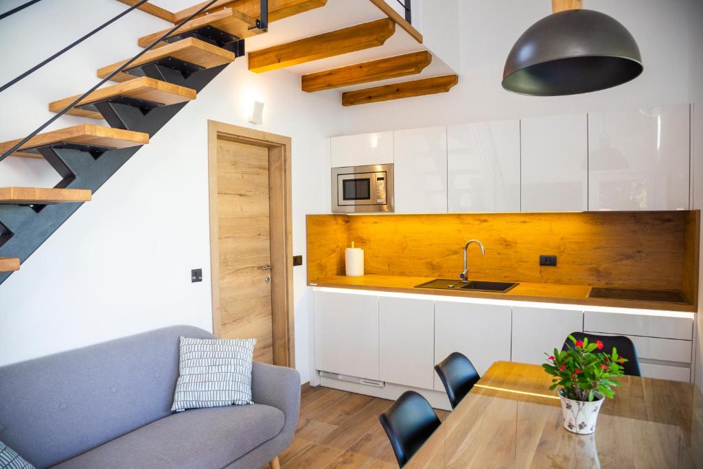 een keuken en een woonkamer met een tafel en een trap bij Holiday Houses Portoroz in Portorož