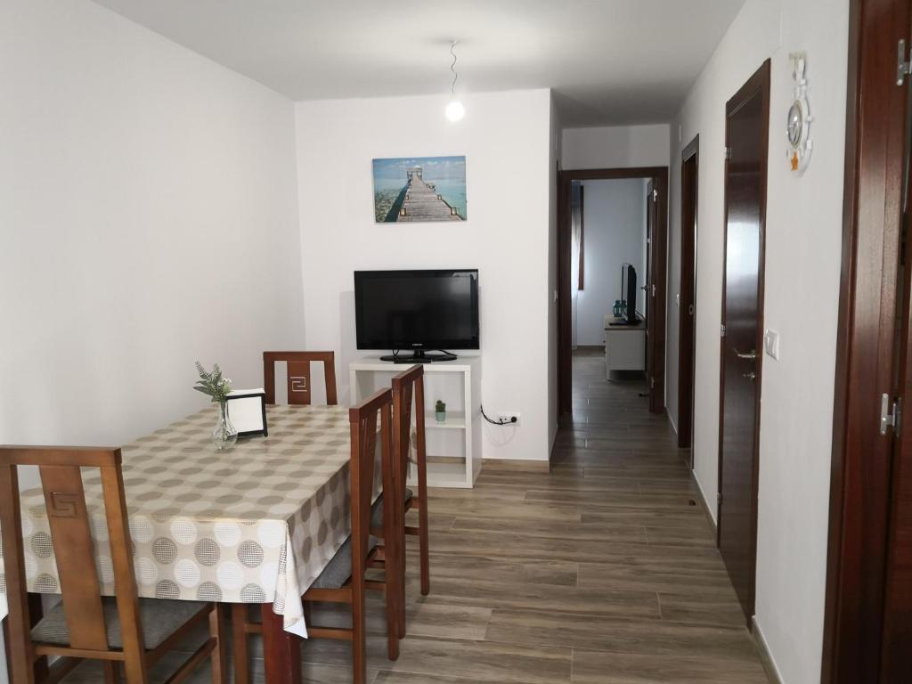 comedor con mesa, sillas y TV en Apartamento en casa Portonovo vacaciones, en Portonovo