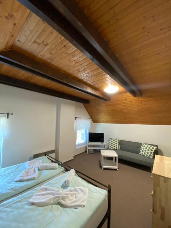 pokój z dwoma łóżkami i kanapą w obiekcie Penzion & Restaurace U Vily w mieście Sezimovo Ústí