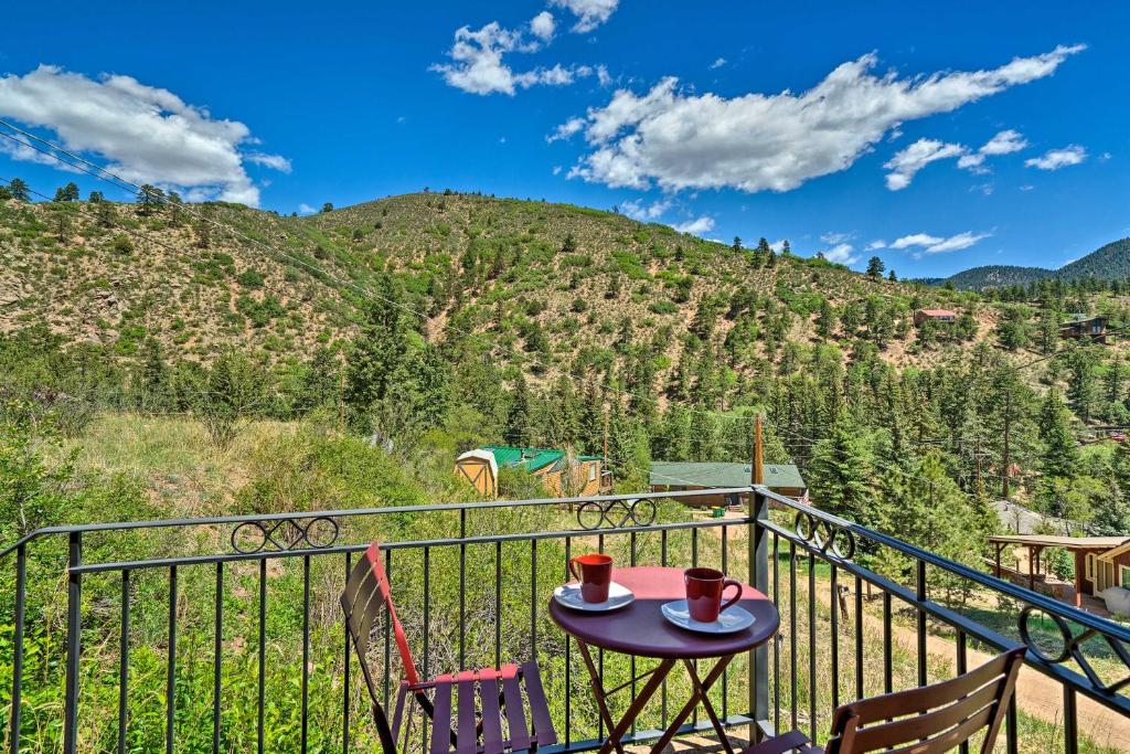a table on a balcony with a view of a mountain at Cozy CO Rocky Mountain Retreat Near Pikes Peak! in Green Mountain Falls
