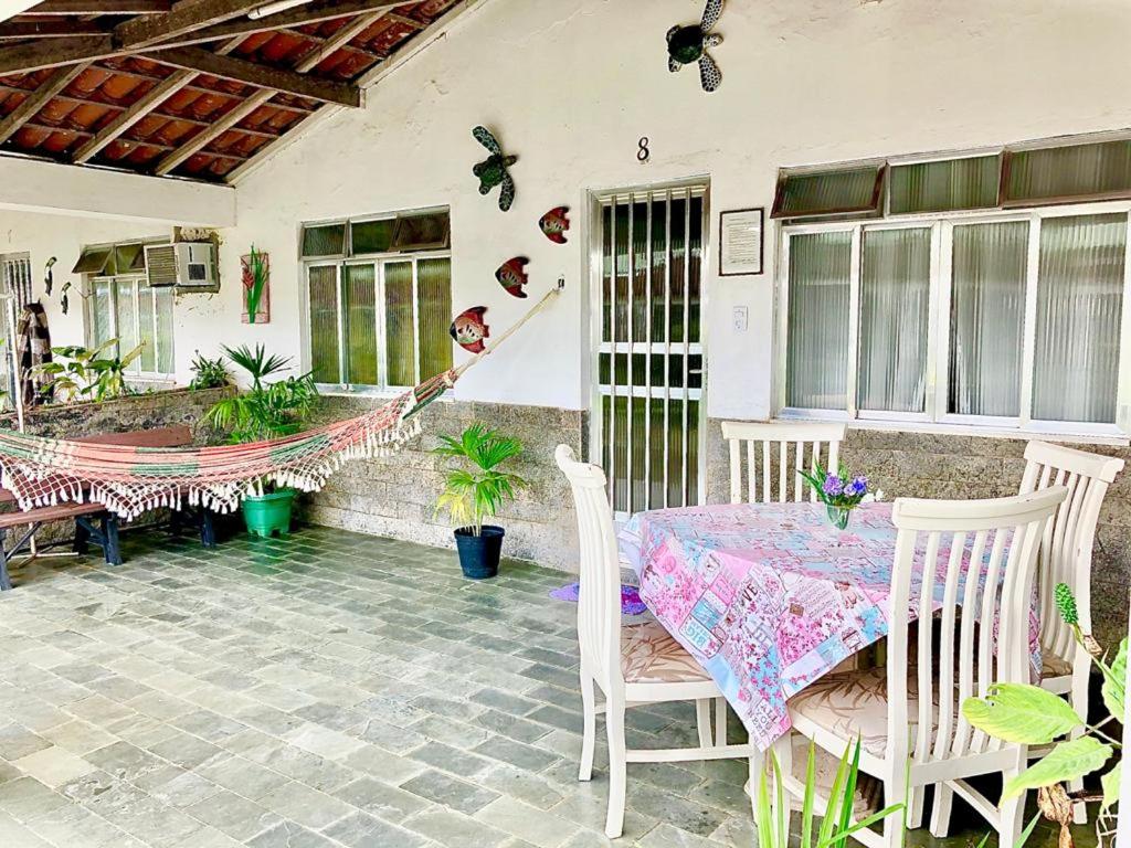 eine Terrasse mit einem Tisch, Stühlen und Pflanzen in der Unterkunft Casa 8 condomínio Angra mambucaba in Angra dos Reis