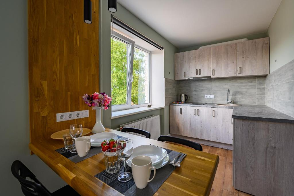 een keuken met een houten tafel met stoelen en een eetkamer bij Beachside Oak Studio in Liepāja