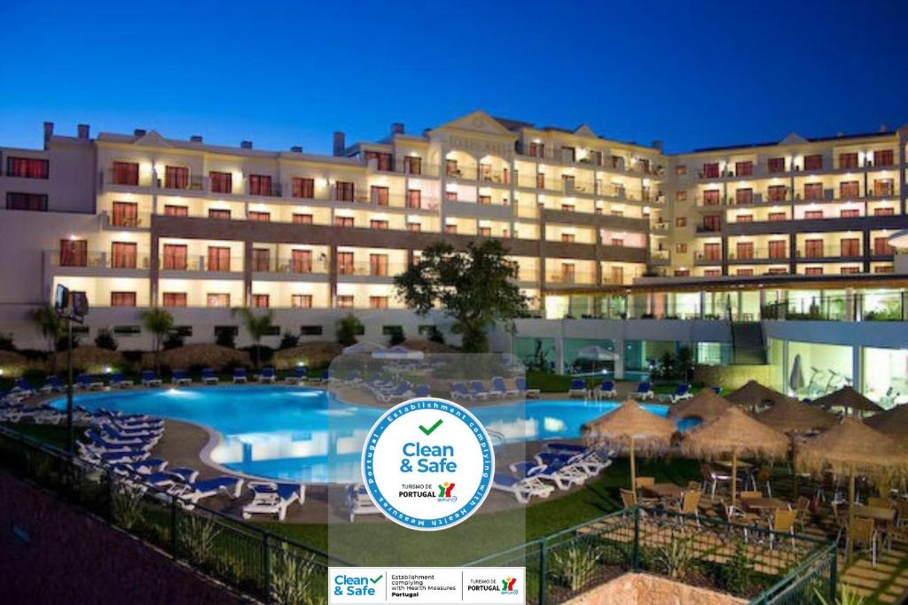 un hôtel avec une piscine, des chaises et un bâtiment dans l'établissement Cerro Mar Atlantico & Cerro Mar Garden, à Albufeira