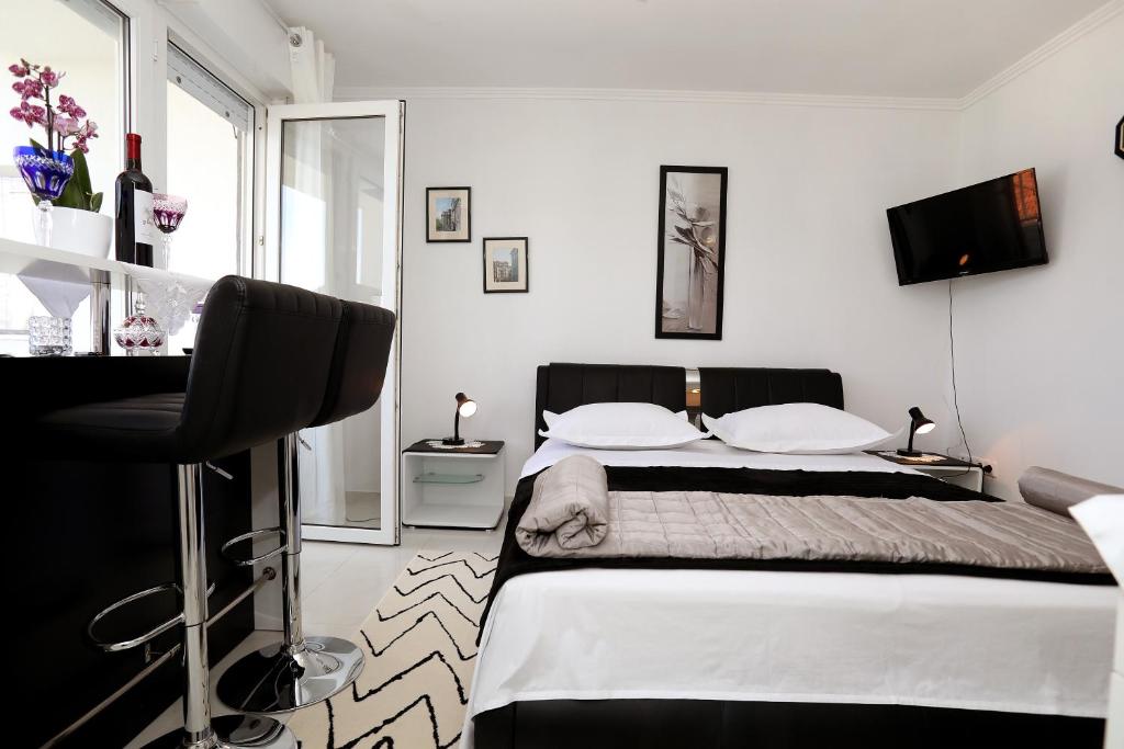 a bedroom with a large bed and a desk at Apartments ITD in Trogir