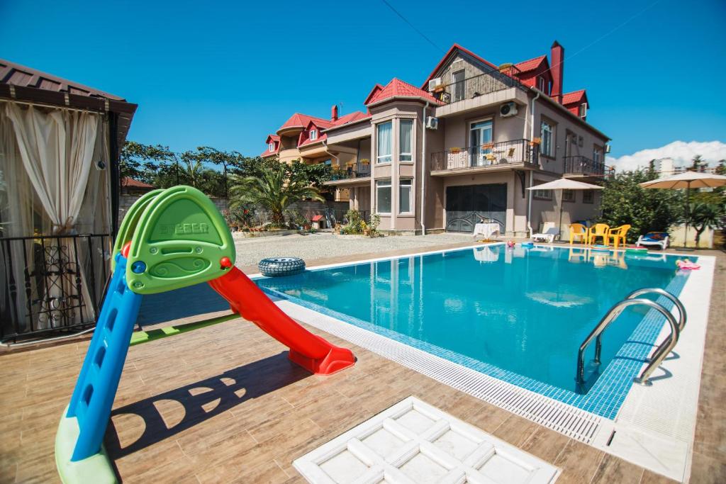 a swimming pool with a slide in front of a house at #HOME-11 in Batumi