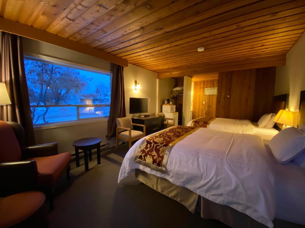 una camera d'albergo con un letto e una grande finestra di Rondo Motel a Golden