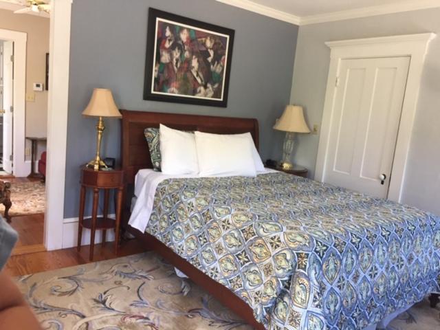 a bedroom with a bed and two tables with lamps at Bourne Bed and Breakfast in Ogunquit